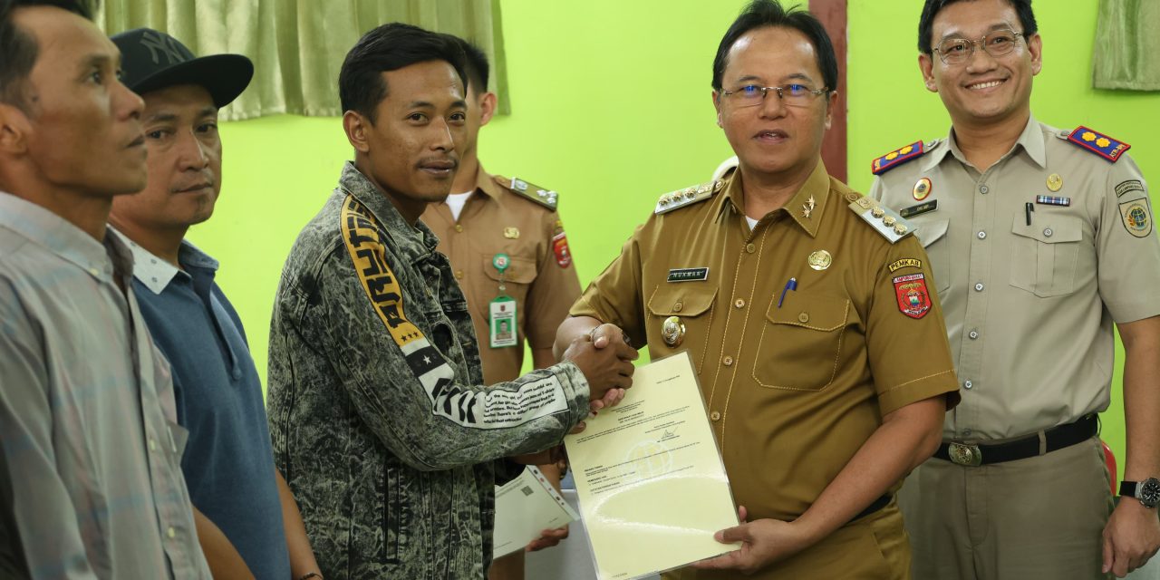 Pj. Bupati Lampung Barat Drs. Nukman, MM., serahkan sertipikat hak atas tanah program strategis nasional kegiatan PTSL tahun 2024